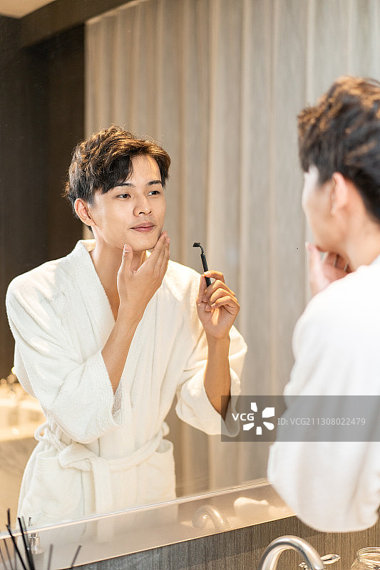 在酒店客房刮胡子的差旅人士图片素材