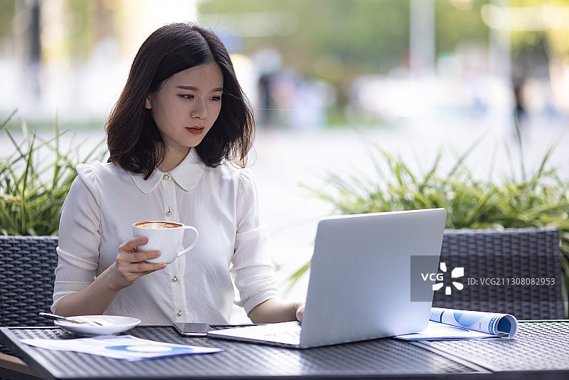 商务女士在咖啡厅使用笔记本电脑工作图片素材