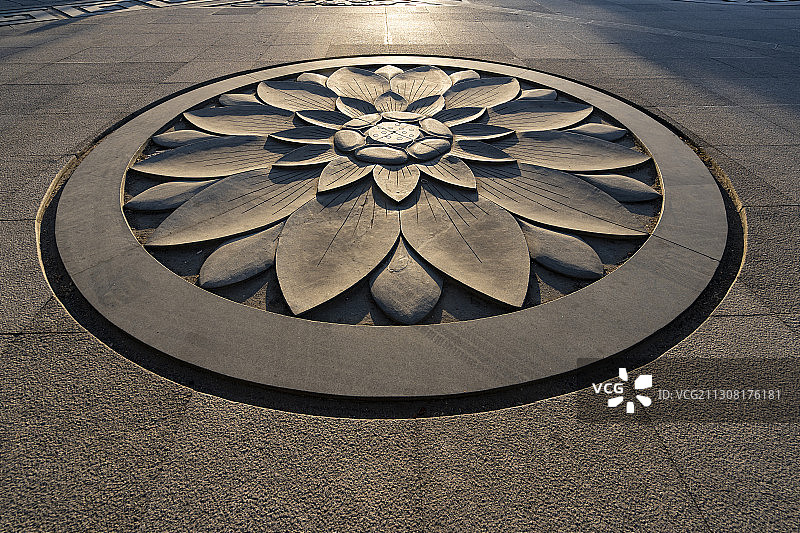 阳光照射在地板上的莲花石雕上图片素材