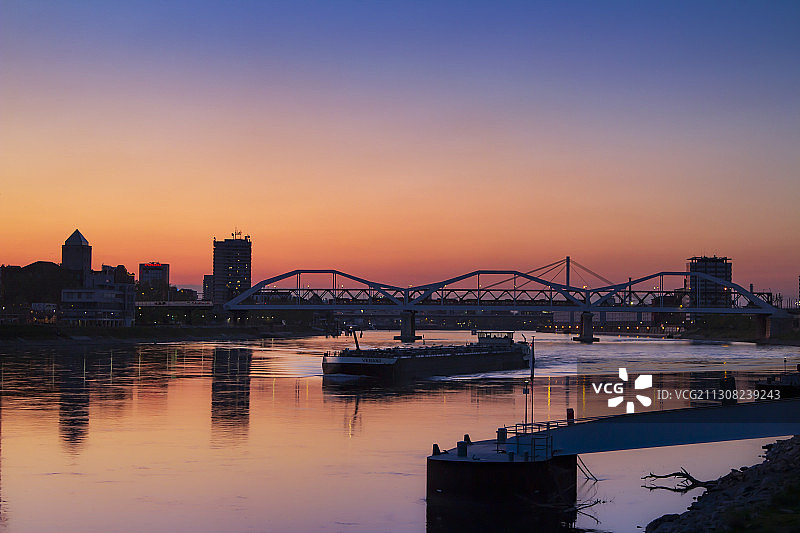 德国曼海姆，日落时分河上桥梁的轮廓图片素材