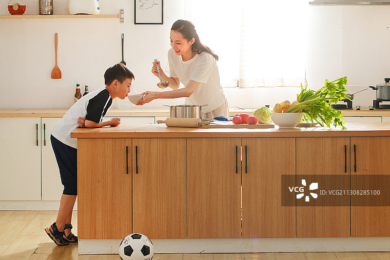 年轻妈妈和儿子在厨房图片素材