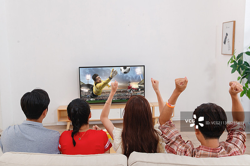 快乐的青年朋友在家看球赛图片素材