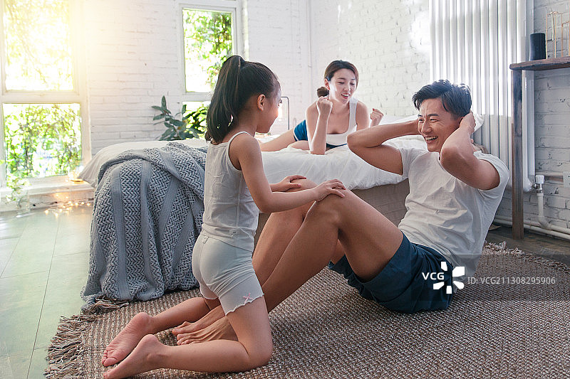 卧室内快乐运动的三口之家图片素材