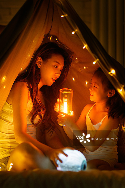 快乐的母女躲在被子里玩耍图片素材