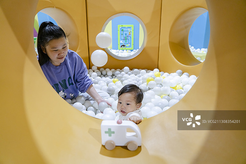 在海洋球堡一起玩乐的母亲与婴儿图片素材