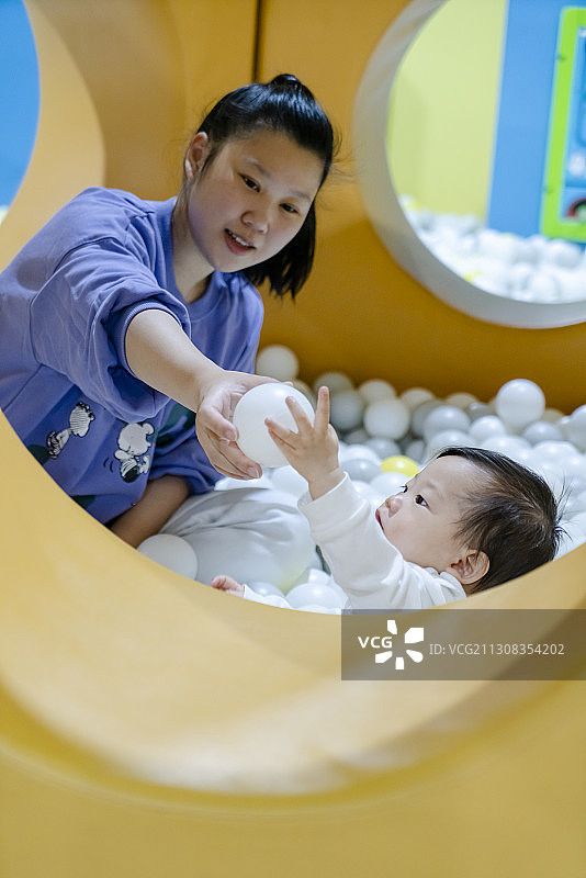 在海洋球堡一起玩乐的母亲与婴儿图片素材