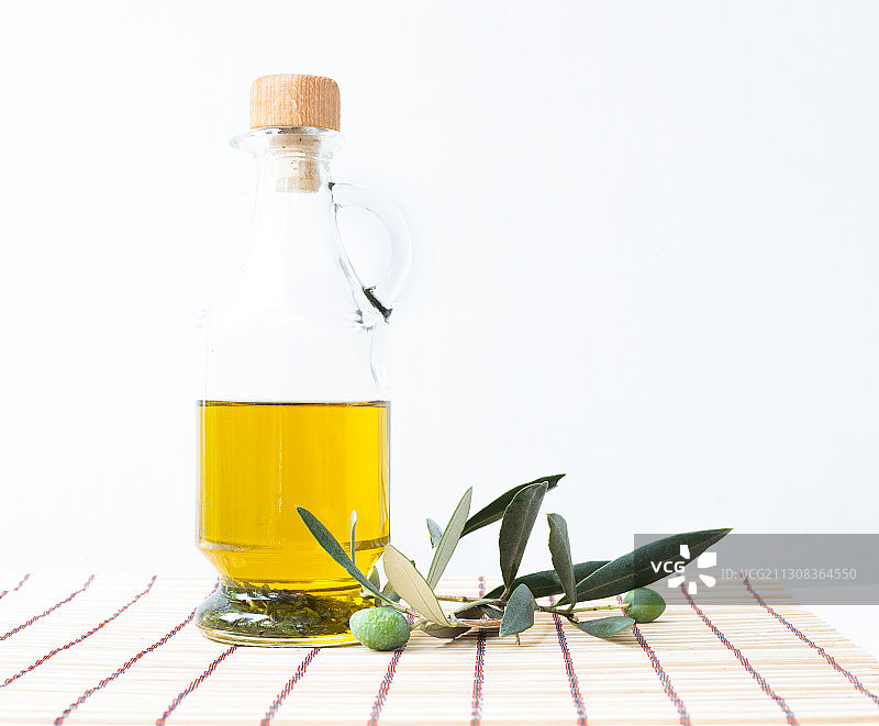 白色背景下桌上的瓶子和树叶特写图片素材