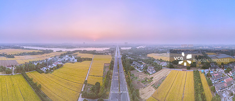 鸟瞰日落时分的江苏无锡锡东新城宛山荡湿地，白墙黑瓦，稻田金黄图片素材