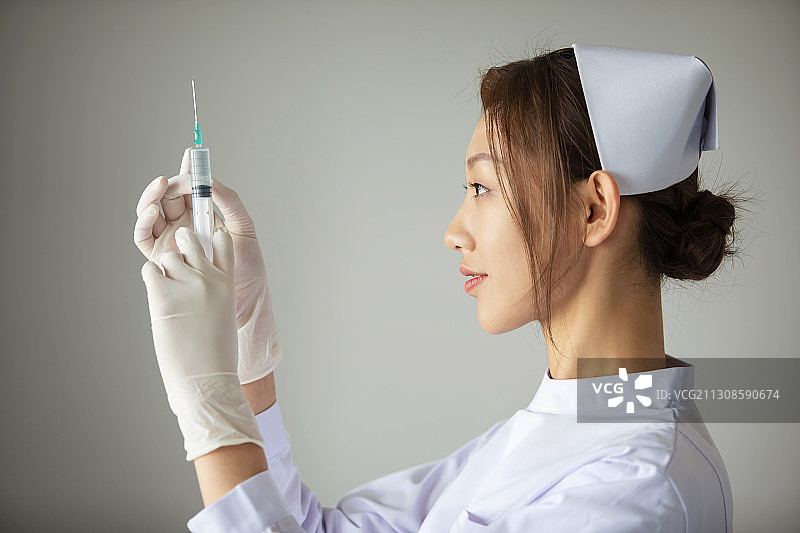 东方年轻女护士拿着注射器图片素材