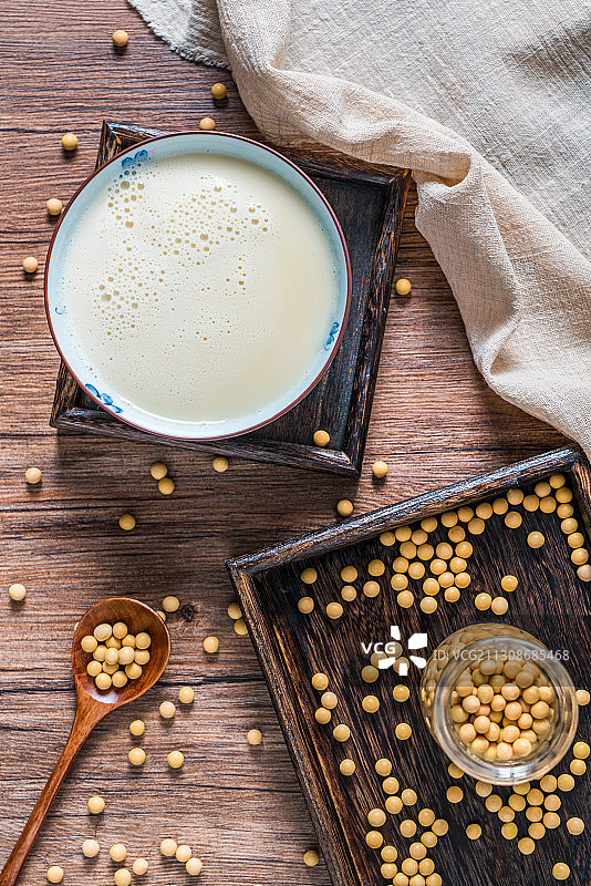 洒在桌面上的许多大豆和一碗豆浆图片素材