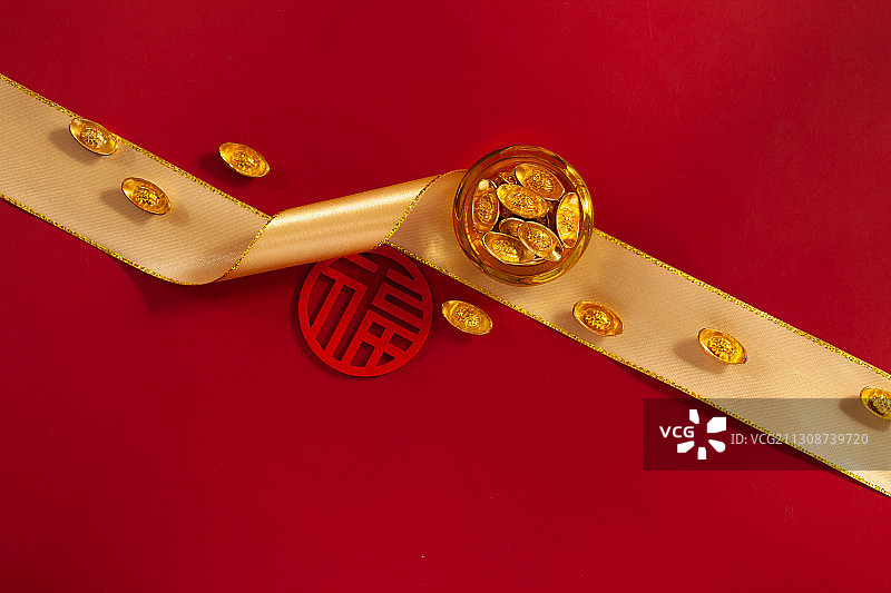 金色绸带上的聚宝盆和金元宝图片素材