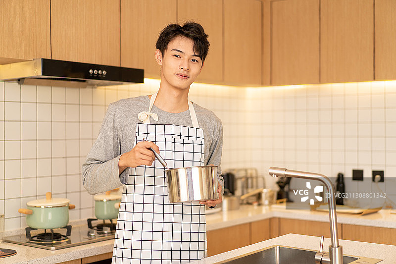 在厨房里看向镜头的男性年轻人图片素材