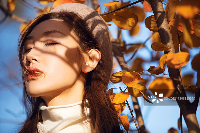 秋天的阳光洒在年轻女子脸上图片素材