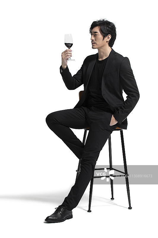 优雅的中年男子品尝红酒图片素材