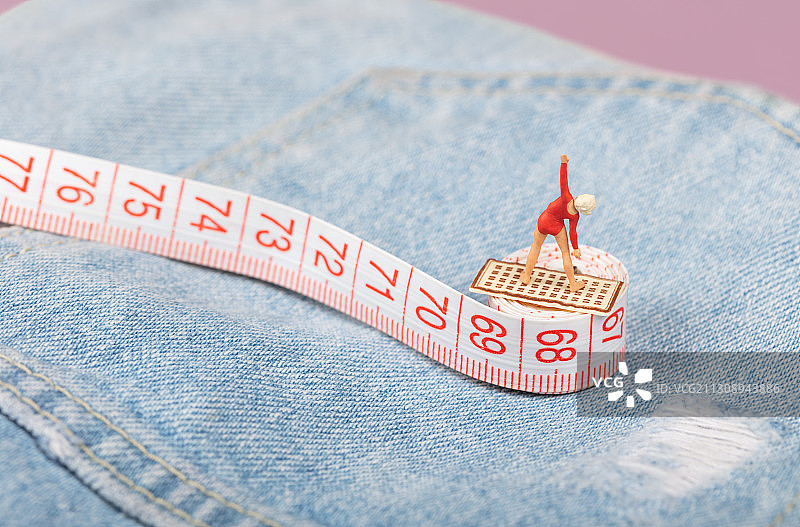 卷尺上的可爱女性伸展运动牛仔裤腰围瘦腰图片素材