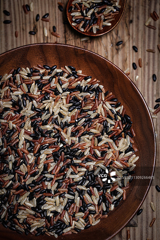 放在黑胡桃木盘子里的三色糙米图片素材