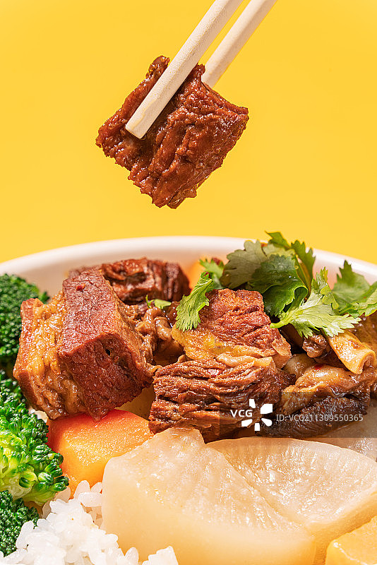 手拿筷子夹美味的牛肉饭图片素材