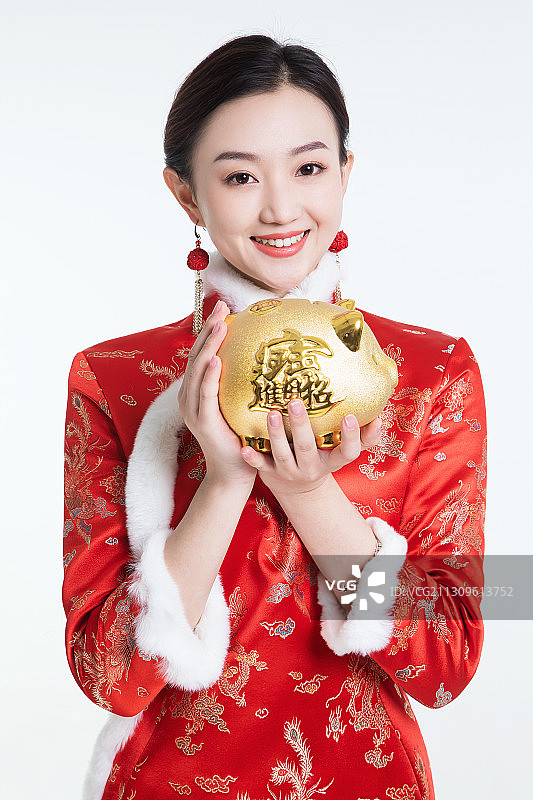 东方年青女子手捧金猪图片素材