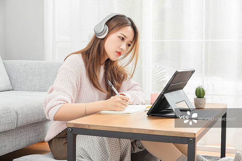 坐在地毯上正在上课的亚洲女孩图片素材