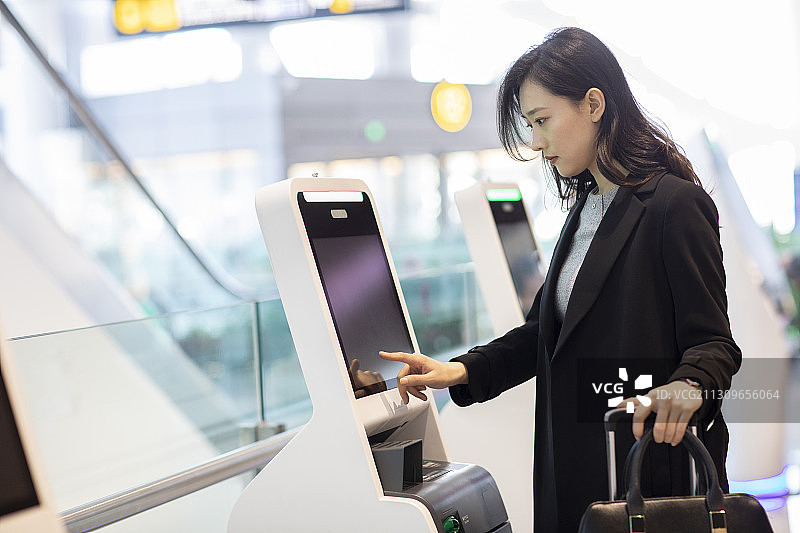 年轻商务女士在机场自助值机图片素材