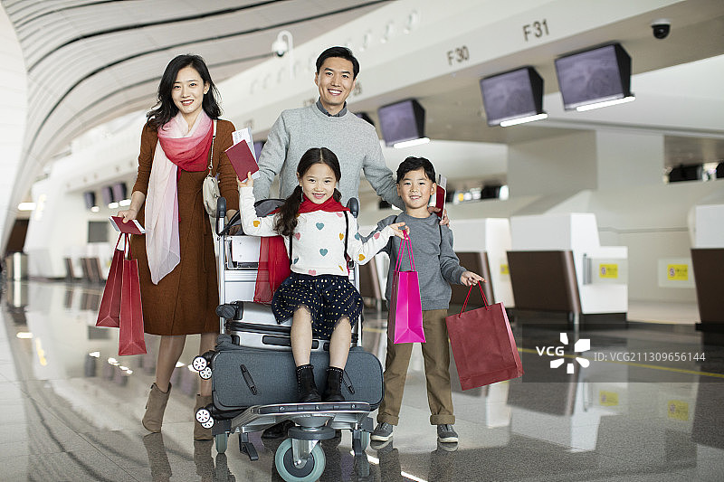 快乐的年轻家庭在机场准备出发去旅行图片素材