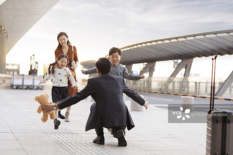 快乐的年轻家庭在机场团聚图片素材