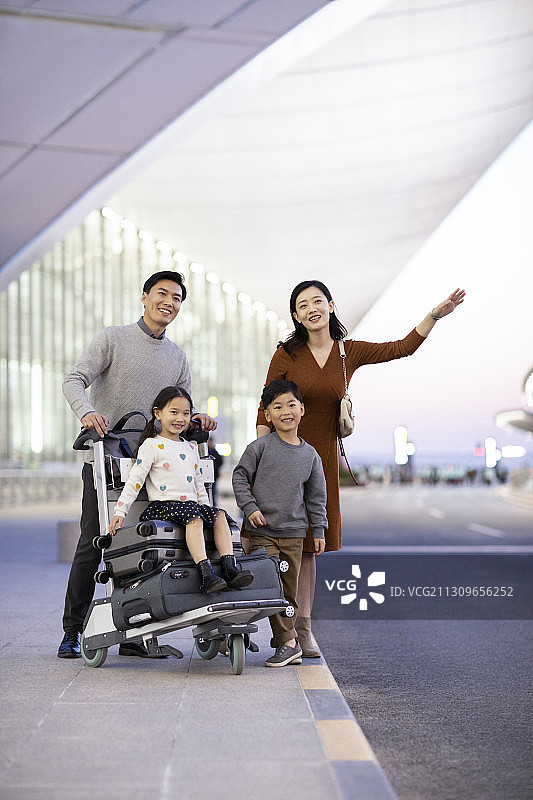 快乐的年轻家庭在机场打车图片素材