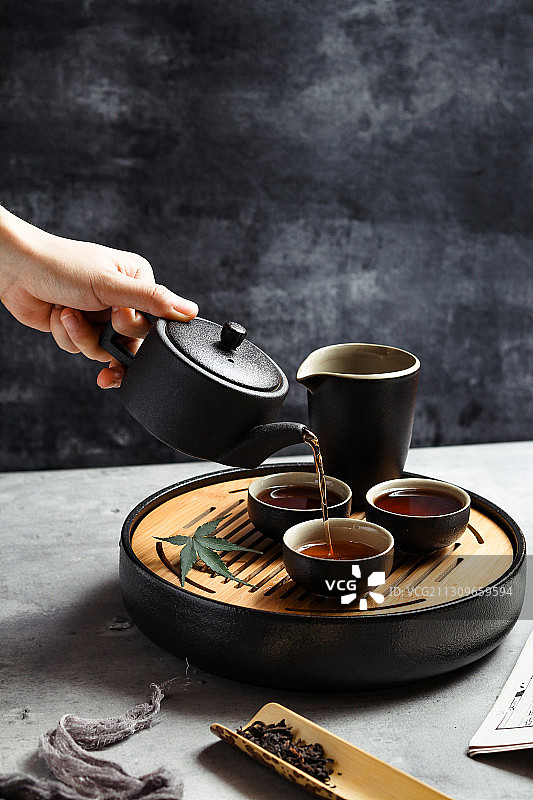 手握茶壶倒茶图片素材