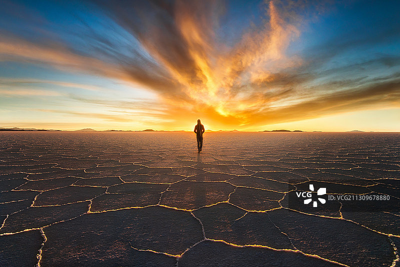 南美玻利维亚的天空之境乌尤尼盐湖，日落下行走的人和盐的结晶图片素材