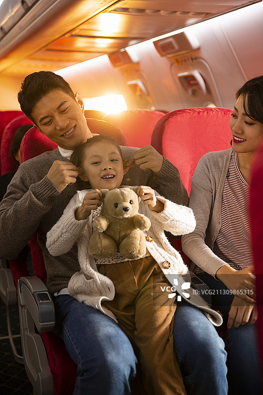 一家三口春节回家在飞机上玩游戏嬉戏图片素材