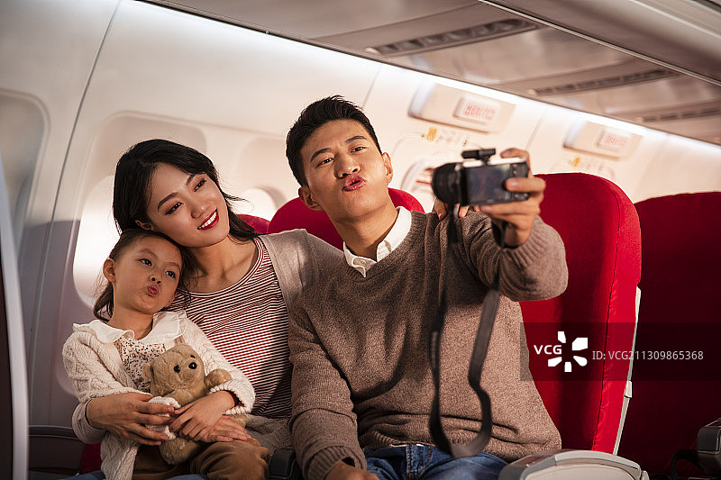 一家三口在飞机上拿着相机自拍图片素材