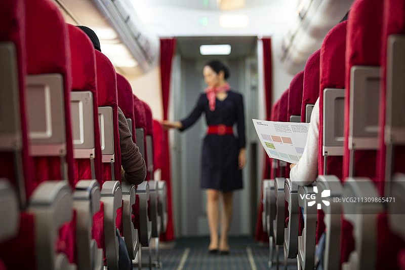 空姐在飞机机舱做检查乘客安全带工作图片素材