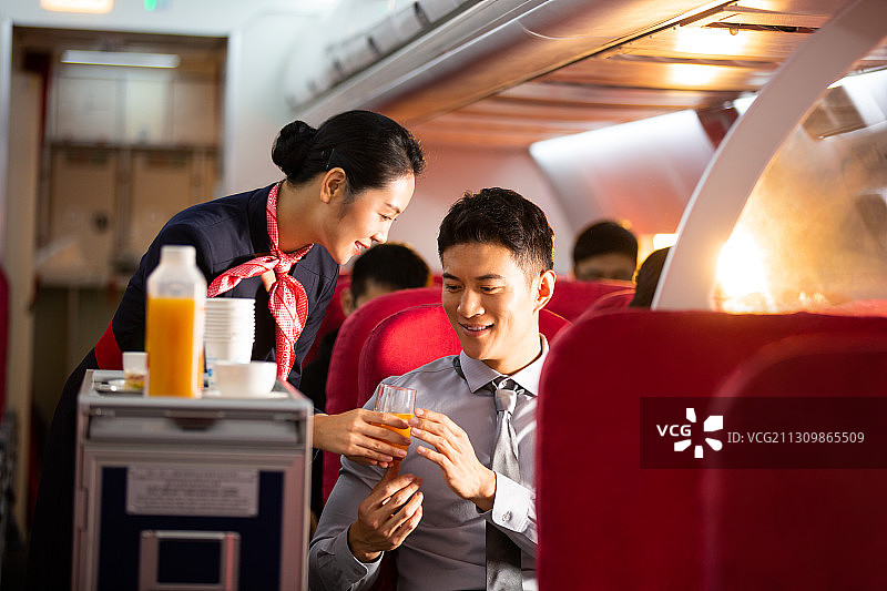 乘务员给男商务乘客果汁图片素材