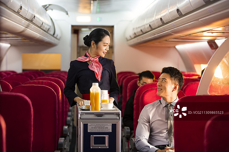 推着餐车乘务员和男商务乘客图片素材
