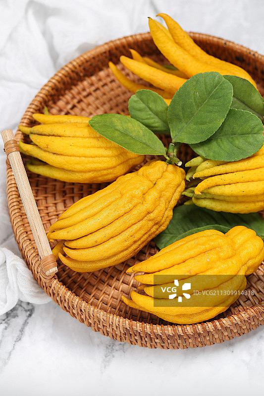 放在竹盘里的黄色的佛手柑图片素材