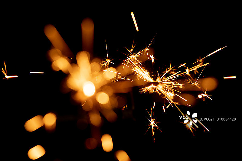 黑色背景下的燃烧的烟花棒和光斑图片素材