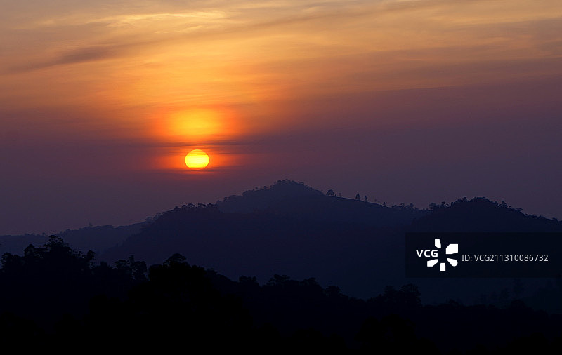 印度卡塔迪马塔姆橙色天空下的山脉剪影图片素材