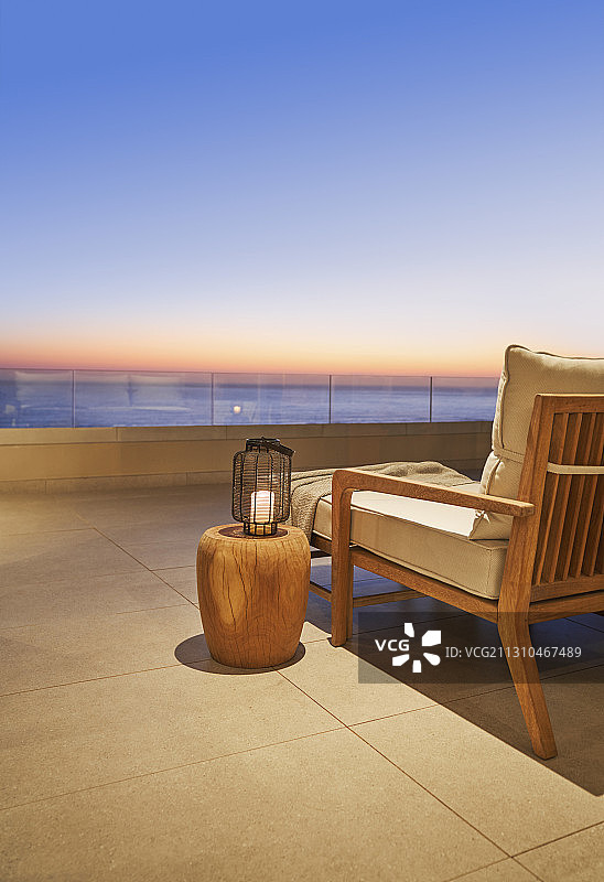 豪华露台上带有日落海景的灯笼和边桌图片素材