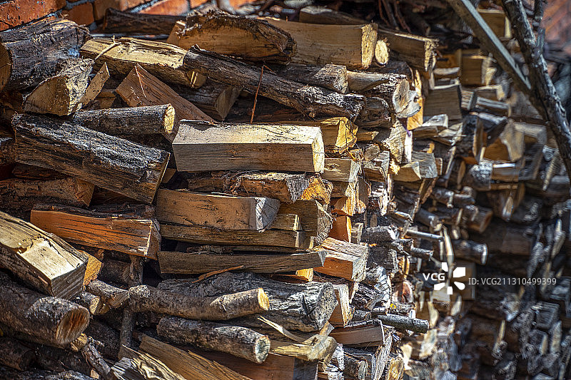 堆放在墙边的用作燃料的木材图片素材