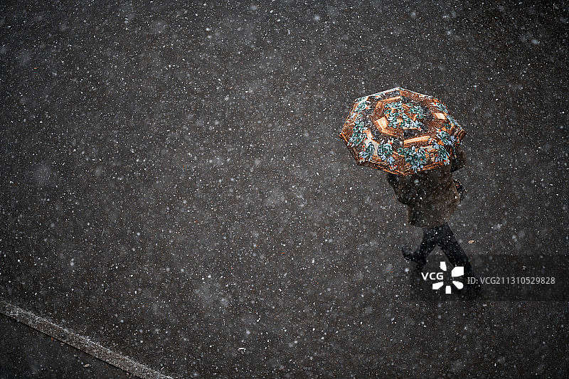 雪中撑伞过马路的女人图片素材