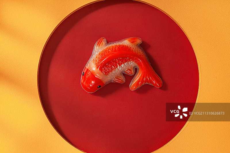 新春红色背景下的年年有余的鱼形年糕图片素材