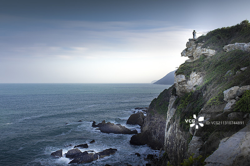 站在悬崖上拍婚纱照的夫妻图片素材