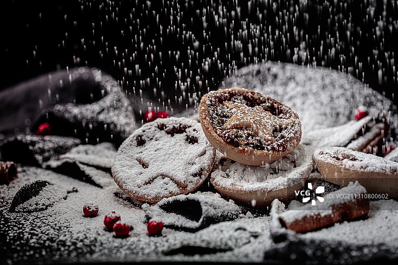 洒在肉馅饼上的糖霜与冬青和肉桂图片素材