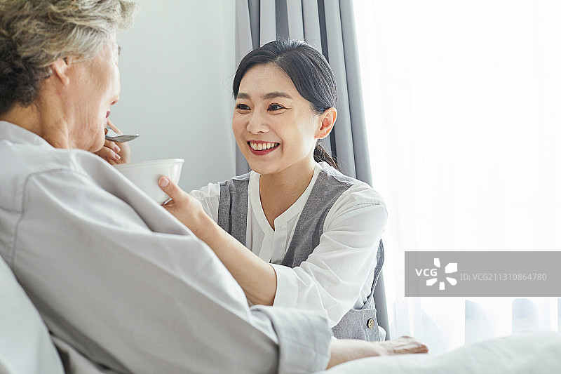 养老院里的老年妇女、护士、护理员、医疗服务、膳食、喂食、微笑图片素材
