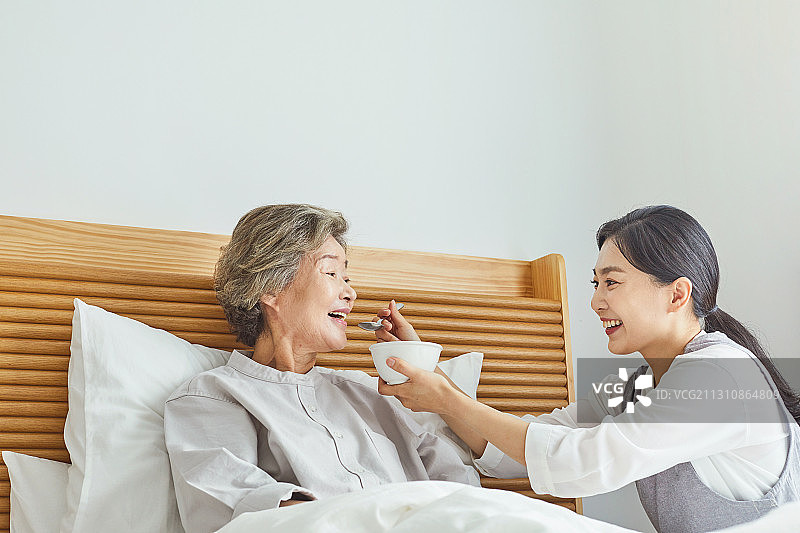 养老院里的老年妇女、护士、护理员、医疗服务、膳食、喂食、微笑图片素材