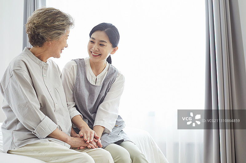 年长的女人，疗养院，护士助理，护理人员，医疗服务，手牵手，微笑，满意，交谈图片素材