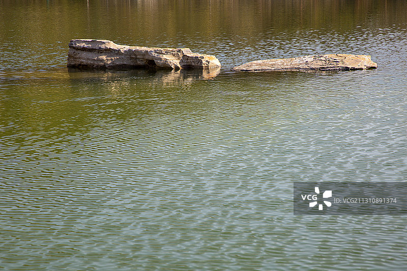 刀削般陡峭的石崖矗立在一池清水之上图片素材