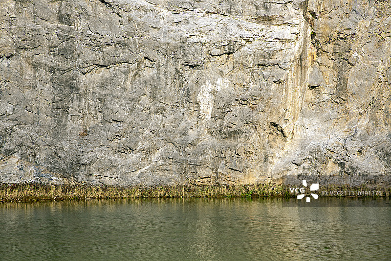 刀削般陡峭的石崖矗立在一池清水之上图片素材
