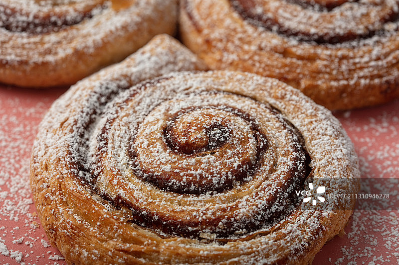 粉色背景上的肉桂卷（俯视）图片素材