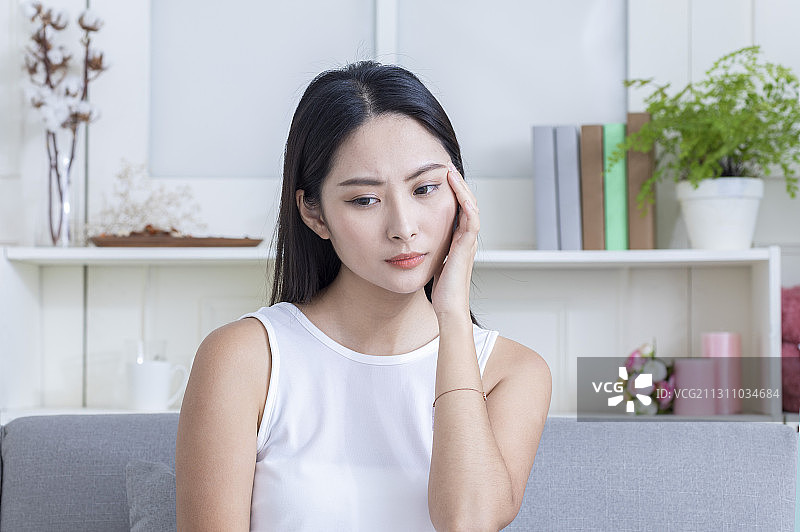 东方美女手托着头皱着眉头图片素材